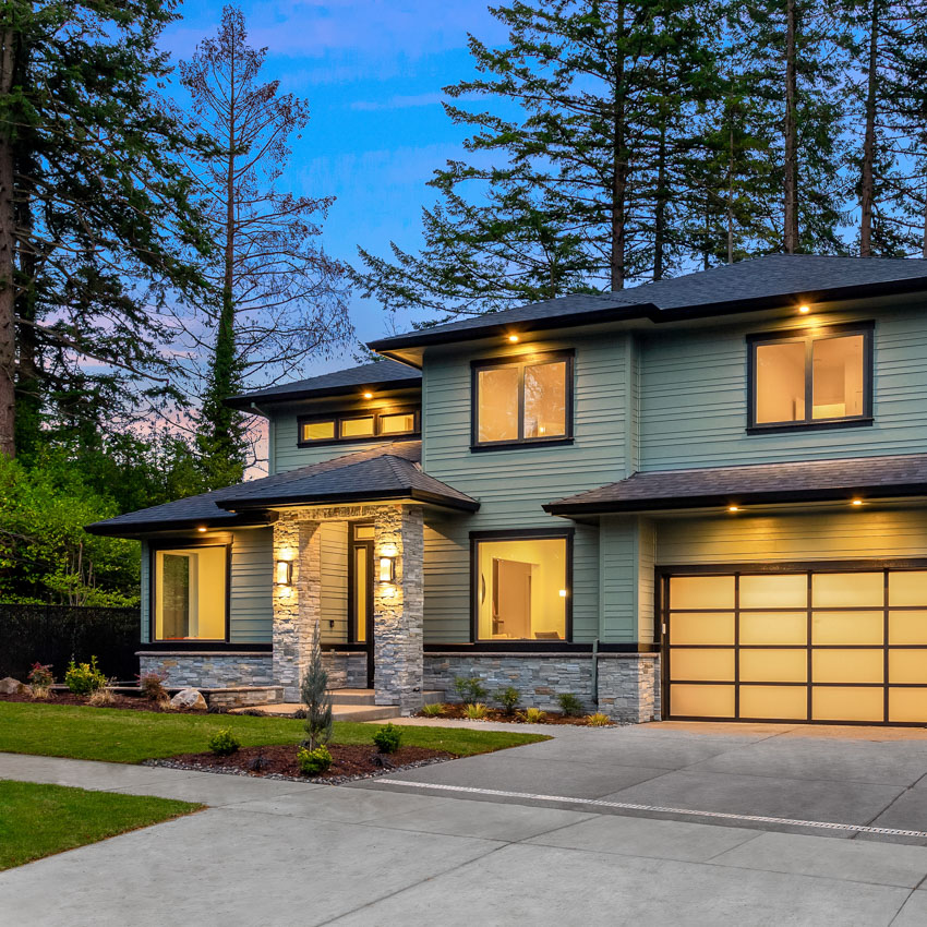 Beautiful modern luxury home exterior at sunset. Features three